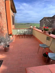 Balkon van vakantieappartement met uitzicht op de glooiende heuvels van Umbrië