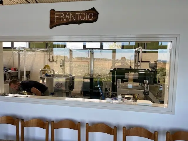 Blik in de frantoio van Agricola Mondovecchio door het vensterraam.